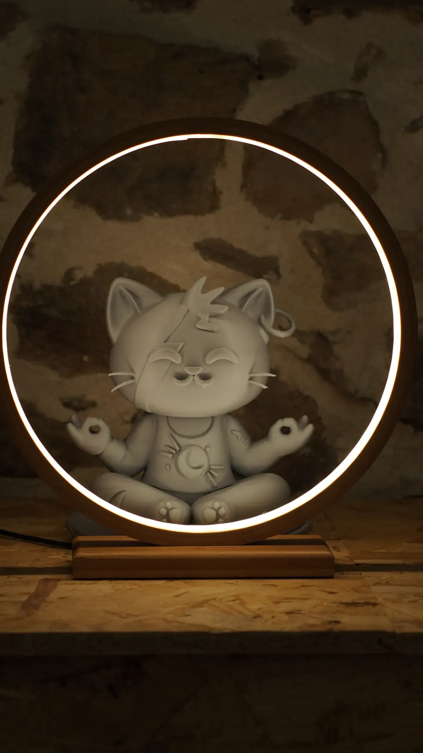 Mascotte du Chat qui Médite, assise en méditation dans un halo lumineux